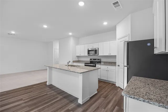 a kitchen with white cabinets and stainless steel appliances