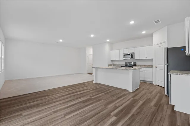 a kitchen with granite countertop a sink stove and refrigerator