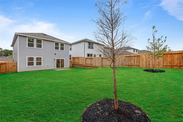 a view of a garden with a house in the background