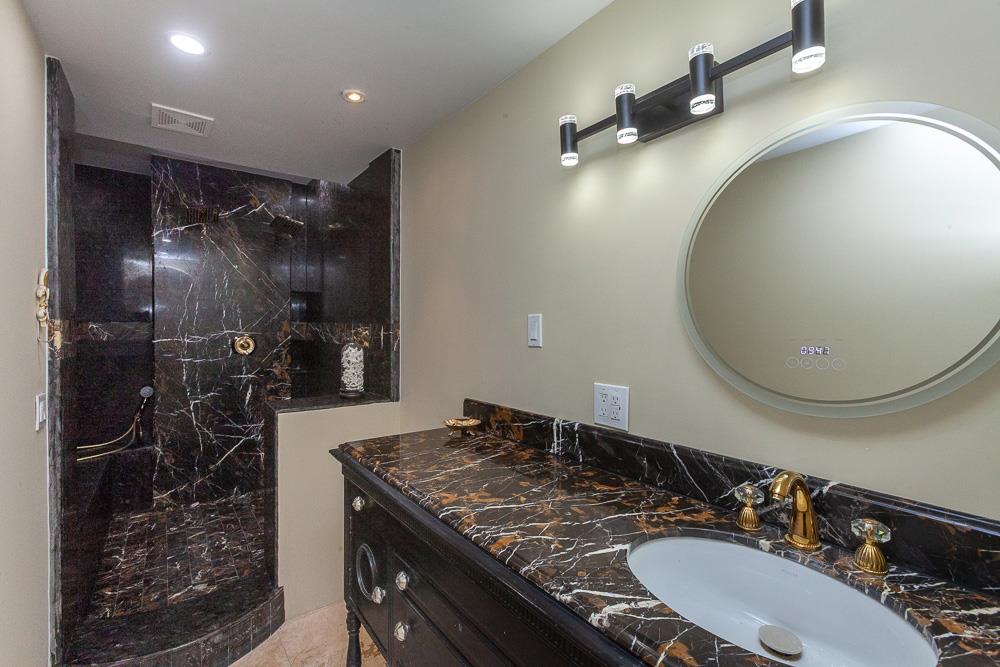 21190 East Acampo Road Clements, CA 95227 - Photo 31 of 89 a bathroom with a granite countertop sink a mirror and shower