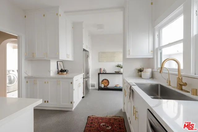 a kitchen with white cabinets and sink