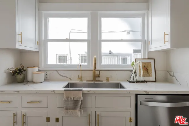 a kitchen with sink a window and cabinets