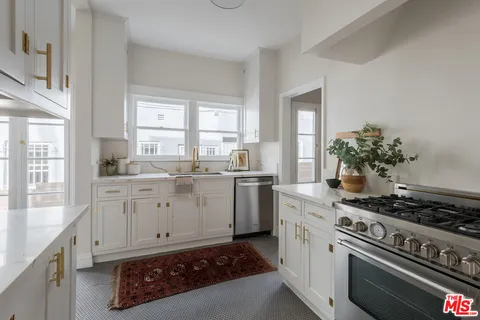 a kitchen with sink stove and cabinets