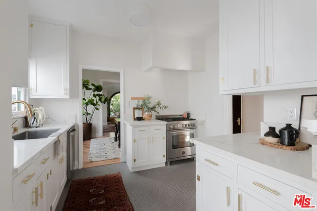 a kitchen with white cabinets and appliances