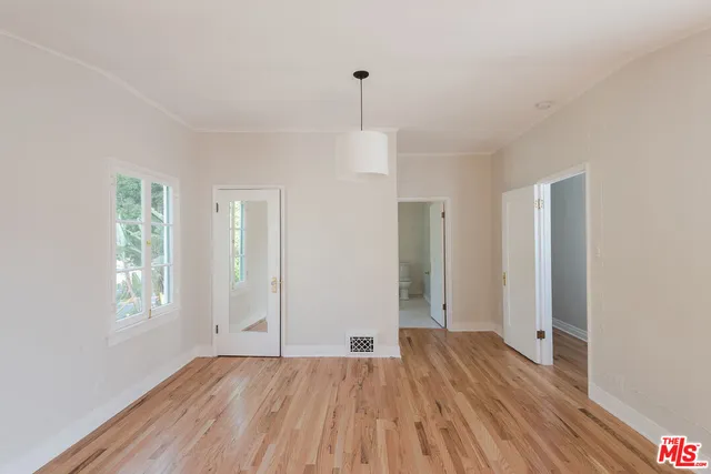 a view of a room with wooden floor and window