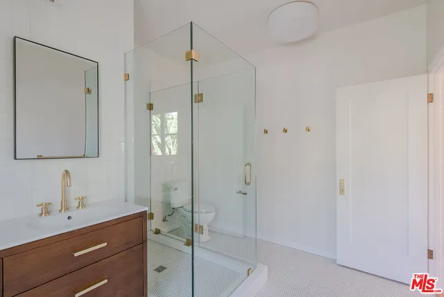 a bathroom with a shower sink and mirror