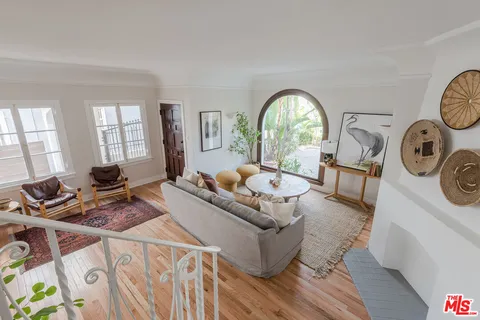 a living room with furniture a window and a clock