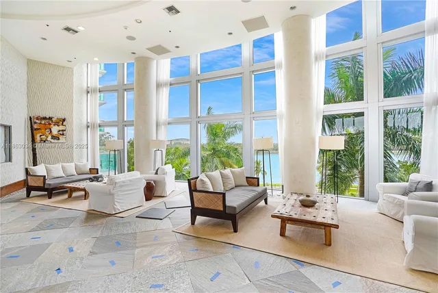 a living room with furniture and floor to ceiling windows