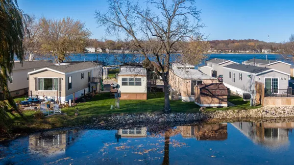 a front view of a house with a yard and lake view