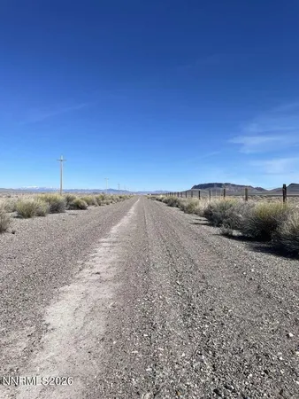 a view of dirt road with a building in the background
