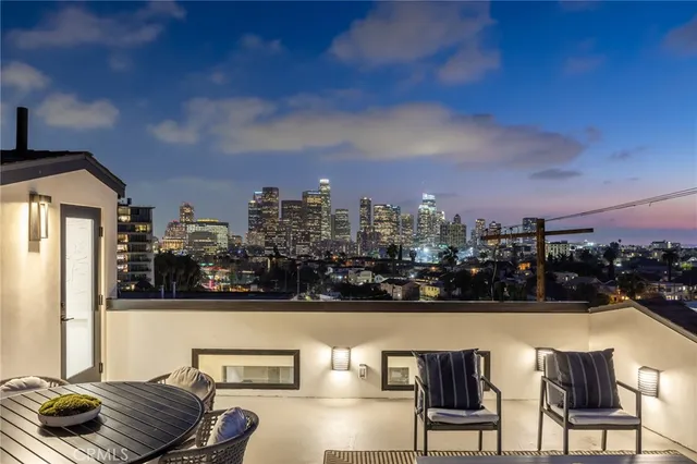 a view of roof deck with seating space and city view