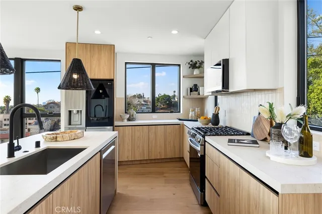 a kitchen with a sink stove top oven and refrigerator