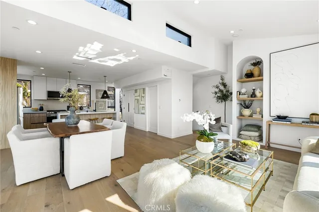 a living room with furniture kitchen view and a chandelier