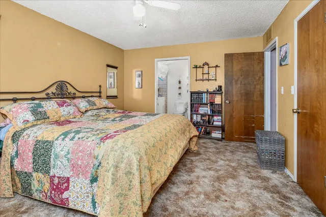 a bedroom with a large bed and a book shelf