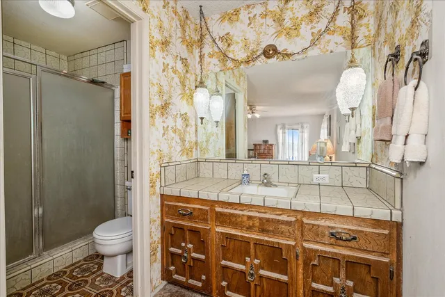 a bathroom with a double vanity sink toilet and shower