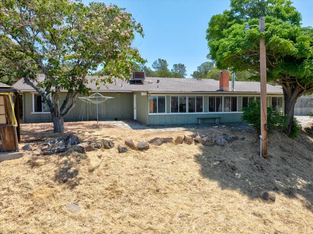a front view of a house with a yard covered with trees