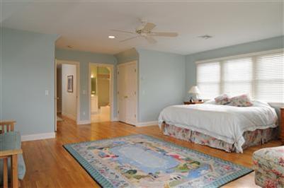 127 West Bay Road, Unit A Osterville, MA 02655 - Photo 10 of 11 a spacious bedroom with a bed and a table
