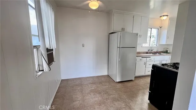 a kitchen with a refrigerator and a stove top oven
