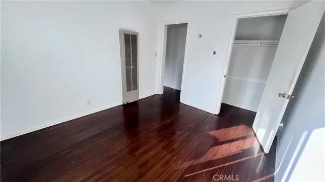 an empty room with wooden floor and entrance