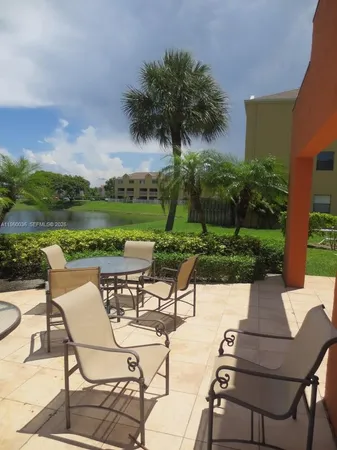 a view of a chairs and table in patio with a lake view