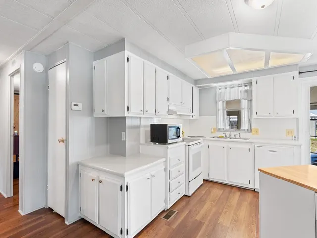 a kitchen with white cabinets and white appliances