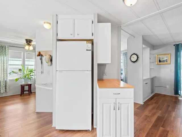 a kitchen with stainless steel appliances a refrigerator and a wooden floor