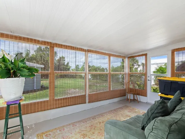 a living room with furniture and a floor to ceiling window