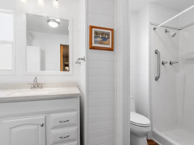 a bathroom with a granite countertop sink a toilet and a mirror