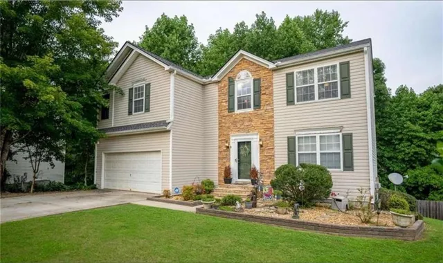 a front view of a house with a garden and yard