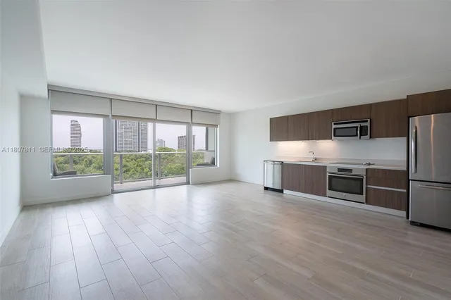 a view of empty room with wooden floor and fireplace