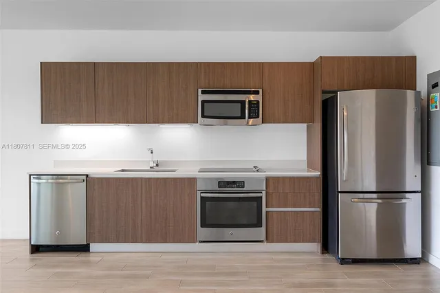 a kitchen with wooden cabinets and stainless steel appliances