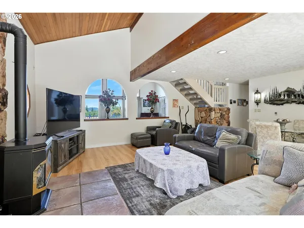 a living room with furniture a flat screen tv and kitchen view