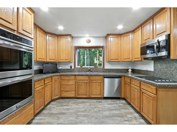 a kitchen with stainless steel appliances kitchen island granite countertop a stove sink and microwave