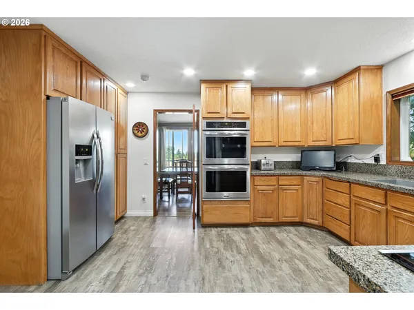 a kitchen with stainless steel appliances granite countertop a refrigerator sink and stove