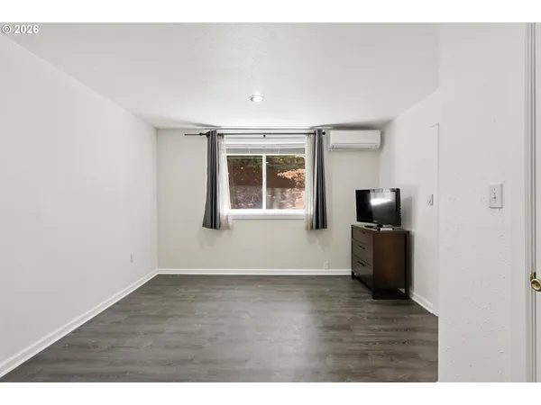 a view of a livingroom with wooden floor and a flat screen tv