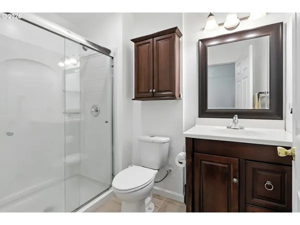 a bathroom with a sink a toilet a mirror and shower