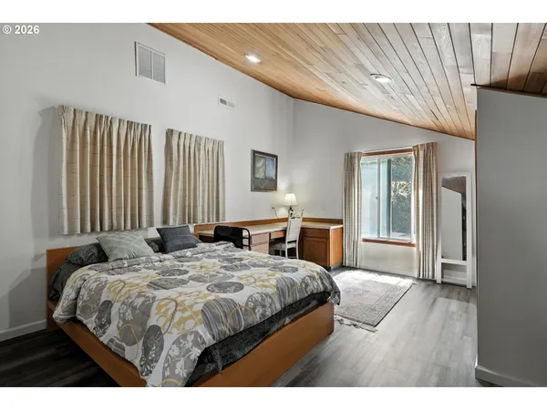 a bedroom with a bed a table and chair