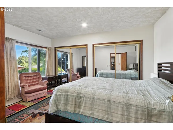 a bedroom with a bed and a large window