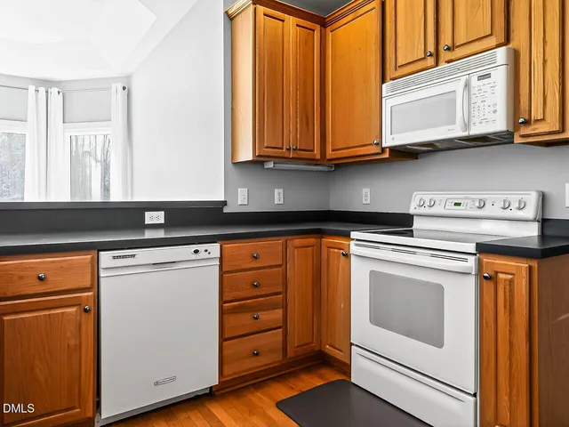 a kitchen with stainless steel appliances granite countertop a sink a stove and cabinets