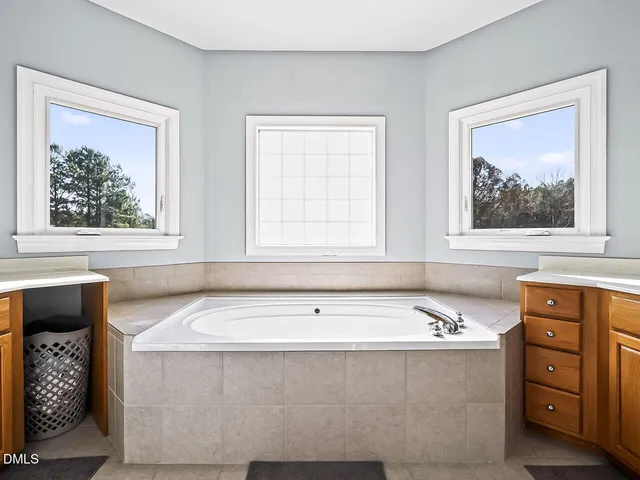 a bathroom with a tub a sink and a window