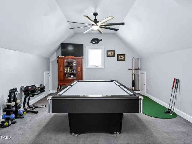 a room with chandelier fan and windows