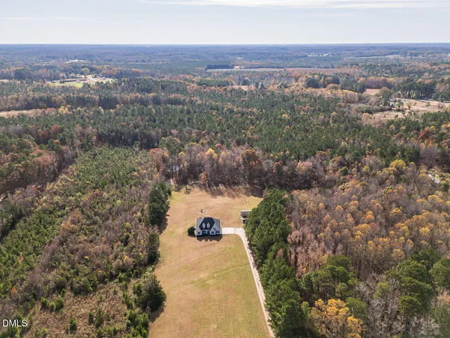 an aerial view of a house with a yard and lake view