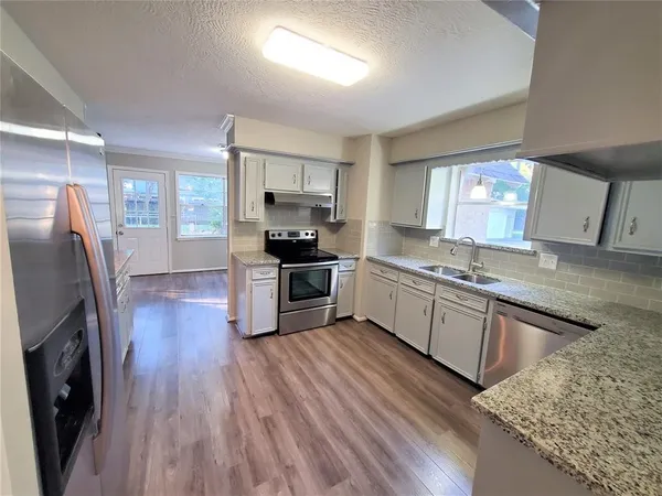 a kitchen with stainless steel appliances wooden floors and wooden cabinets