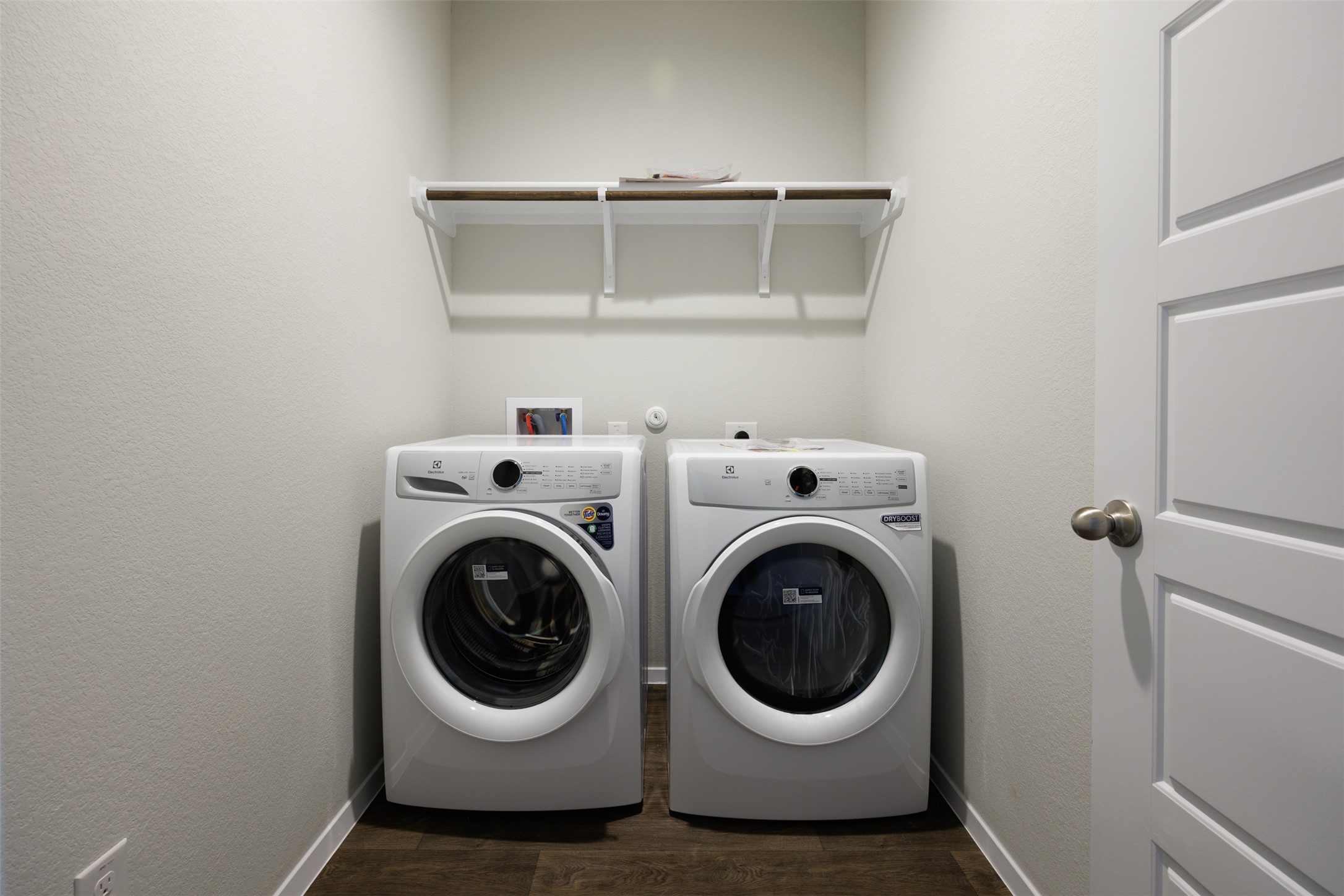 160 Backwater Road Kyle, TX 78640 - Photo 14 of 15 Laundry room featuring washer and clothes dryer, dark wood-style flooring, and a textured wall