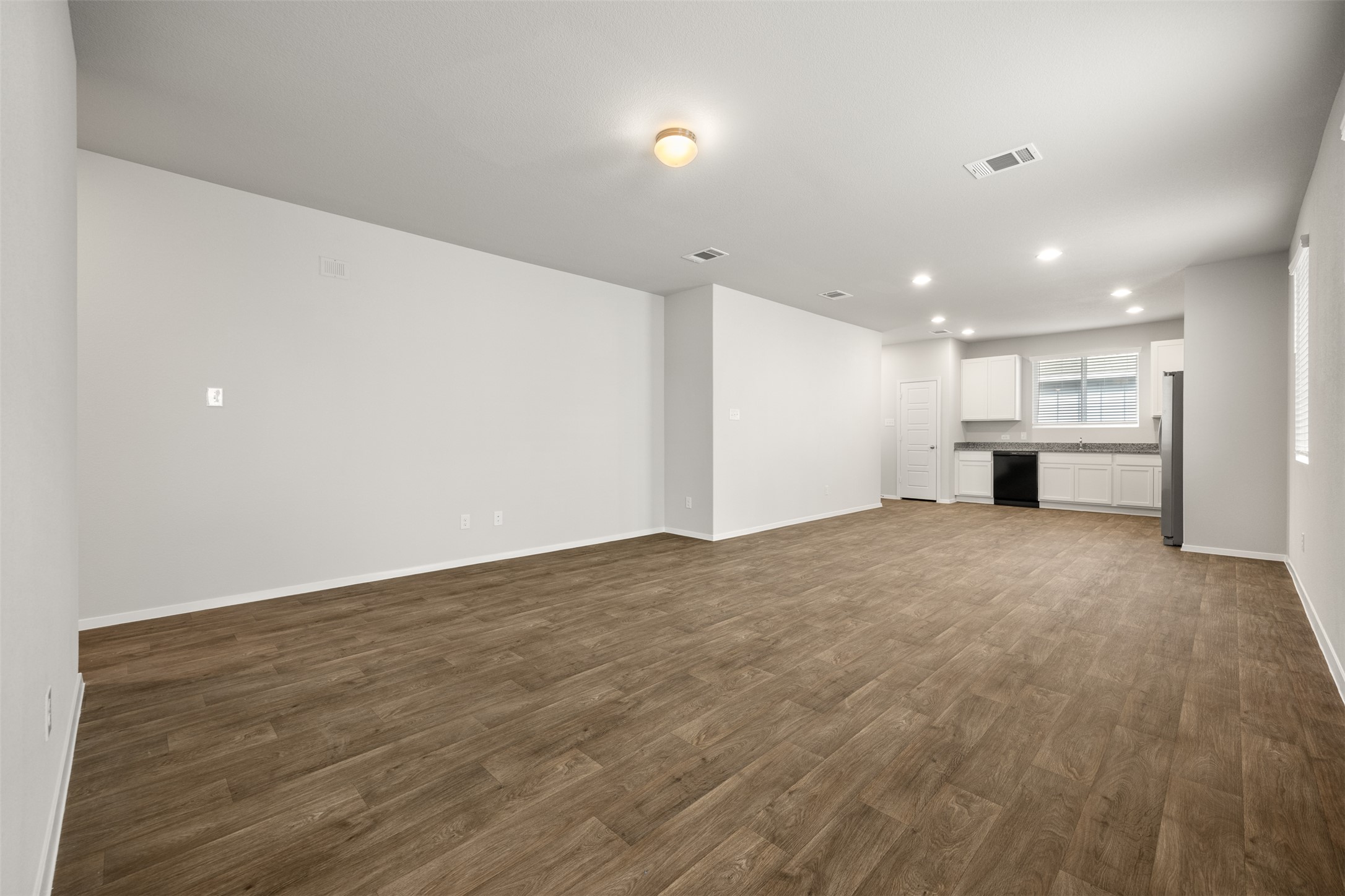 160 Backwater Road Kyle, TX 78640 - Photo 3 of 15 Unfurnished living room with dark wood-type flooring and recessed lighting