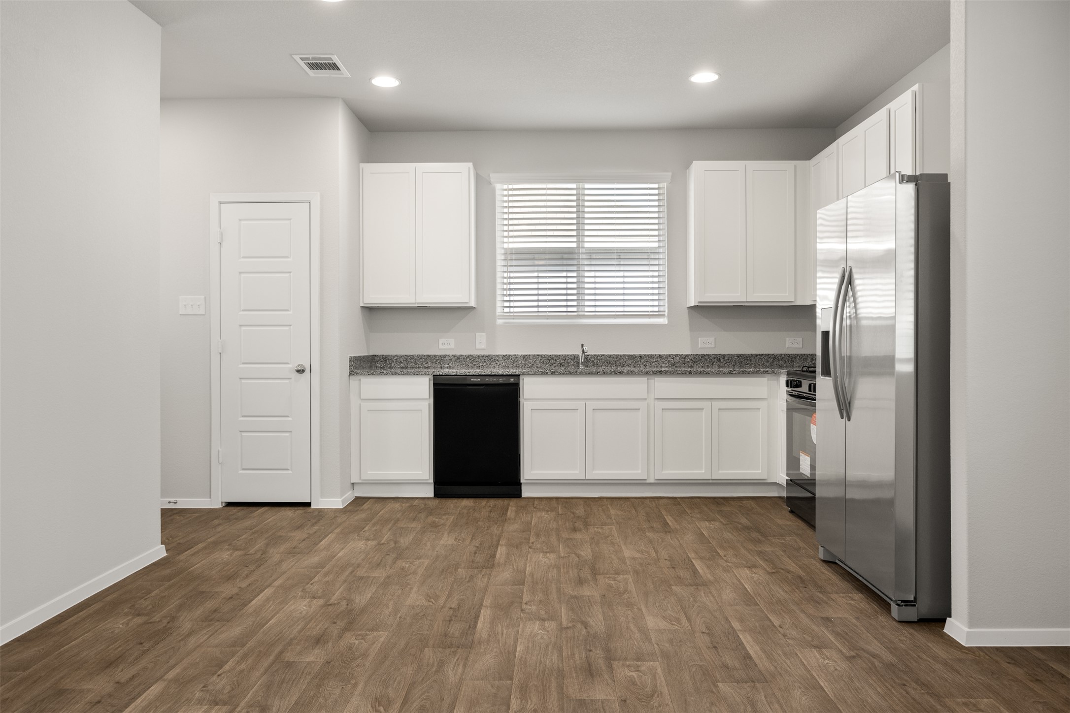 160 Backwater Road Kyle, TX 78640 - Photo 5 of 15 Kitchen with white cabinetry, stainless steel fridge, recessed lighting, and black dishwasher