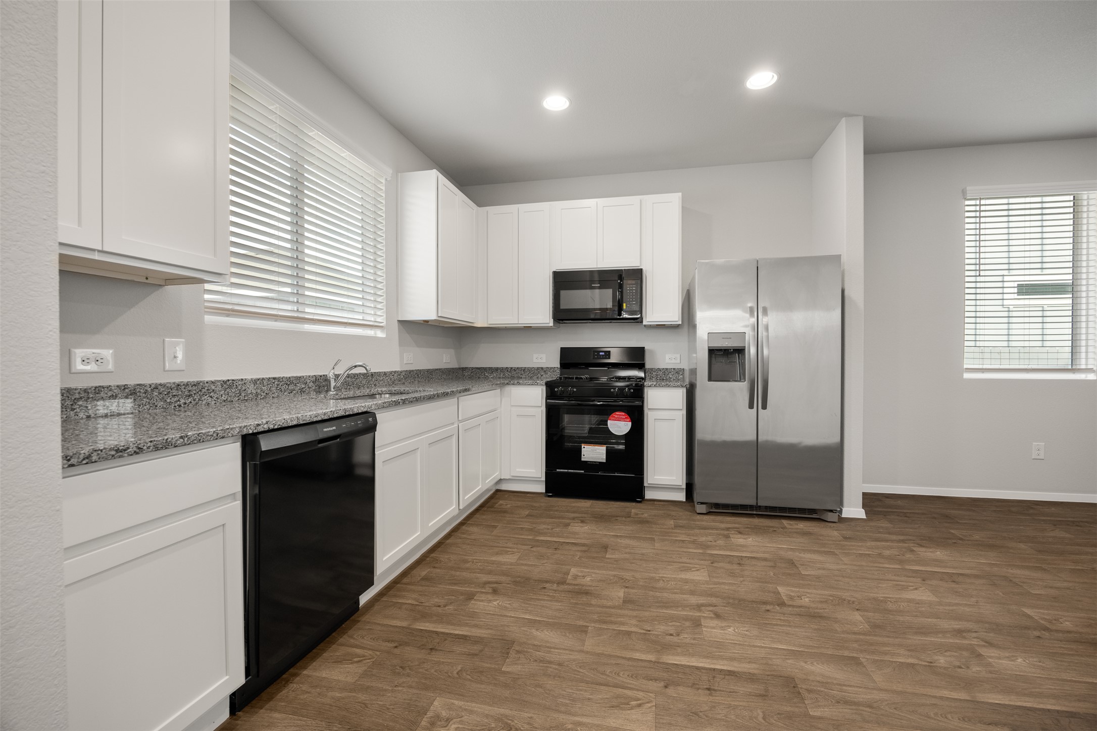 160 Backwater Road Kyle, TX 78640 - Photo 6 of 15 Kitchen with black appliances, white cabinets, recessed lighting, dark wood-style floors, and dark stone countertops