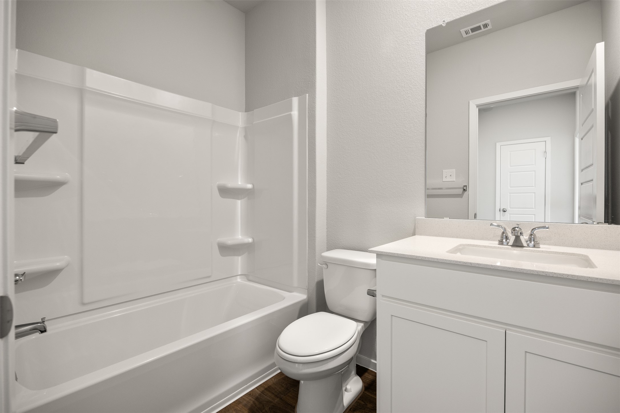 160 Backwater Road Kyle, TX 78640 - Photo 10 of 15 Bathroom featuring vanity, a textured wall, shower / bath combination, and dark wood-type flooring