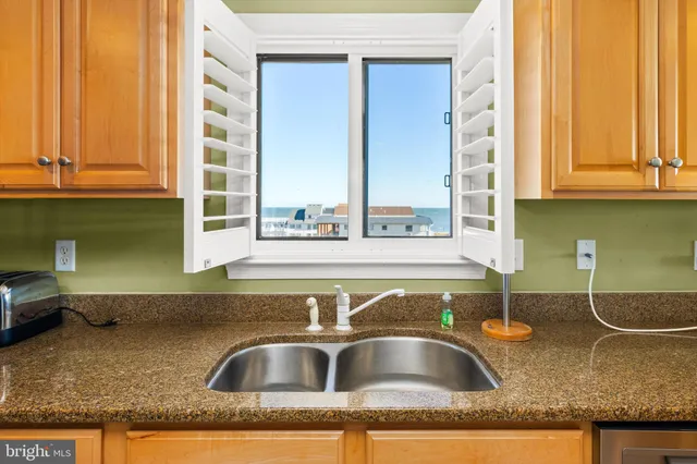 a view of a kitchen counter top a sink and cabinets