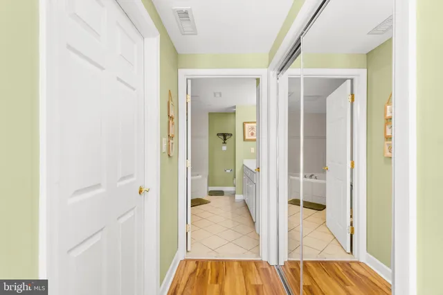 a view of a hallway with wooden floor and a living room